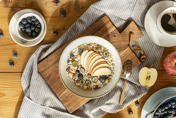 Porridge Mandel Tonka Creme, verteilt in zwei Schüssel und mit Obst angerichtet