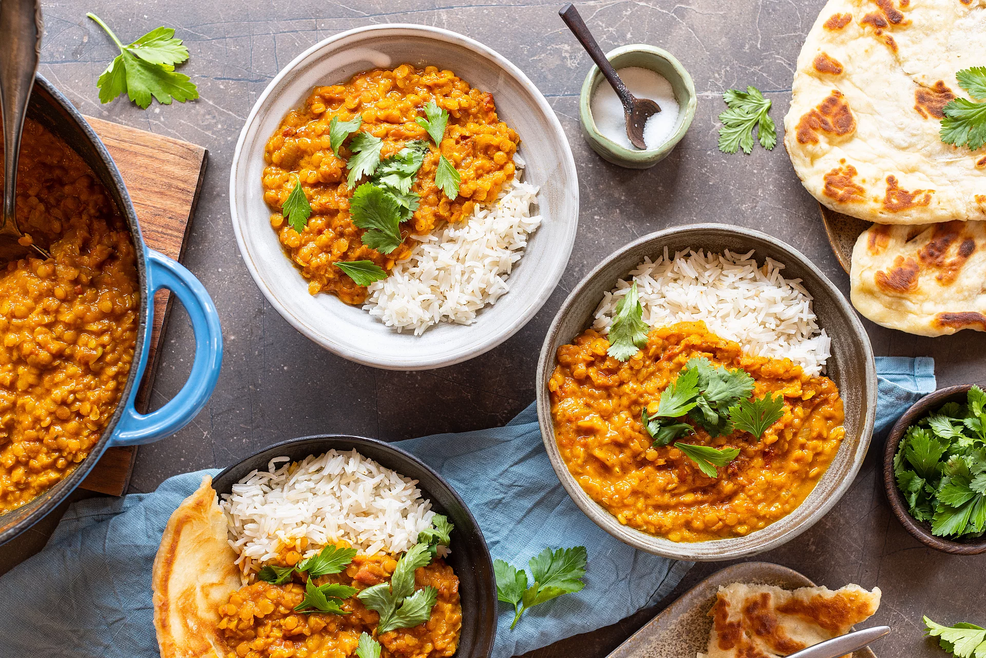 Weißer Reis ist der Klassiker und besonders vielseitig einsetzbar. Linsen Dal und Himalaya Basmati Reis weiß, angerichtet in drei Tellern, daneben Naan.