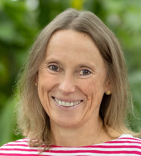 Sabine Wenning Rapunzel Mitarbeiterin steht vor blühender Pflanze.